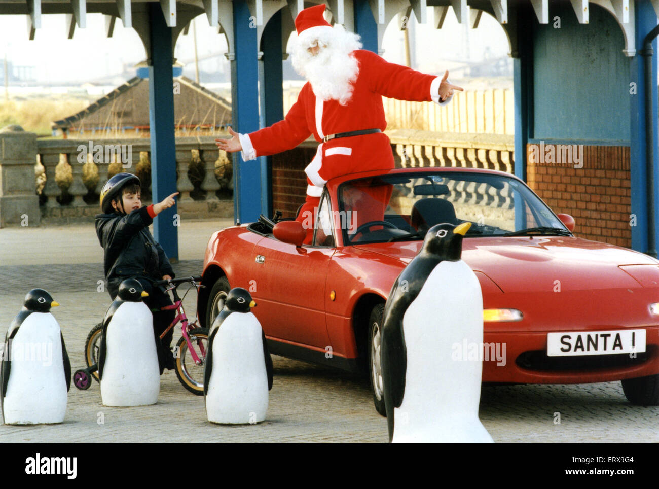 Santa kamen heute früh in Redcar und benötigt ein wenig Hilfe, um seinen Weg nach Hause von drei Jahre alte Stefan Taylor zu finden. 24. November 1995. Stockfoto