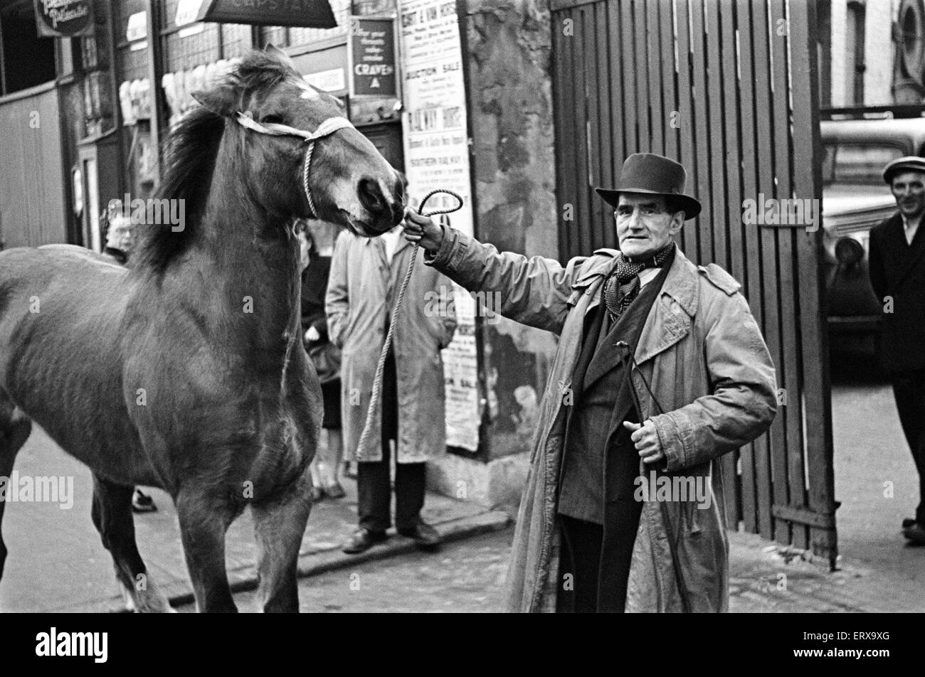 Ein Mann mit einem Pferd, stehen außerhalb des Geländes ein Cart und van Pferdeauktion, New Kent Road, London, ca. Dezember 1947 Stockfoto