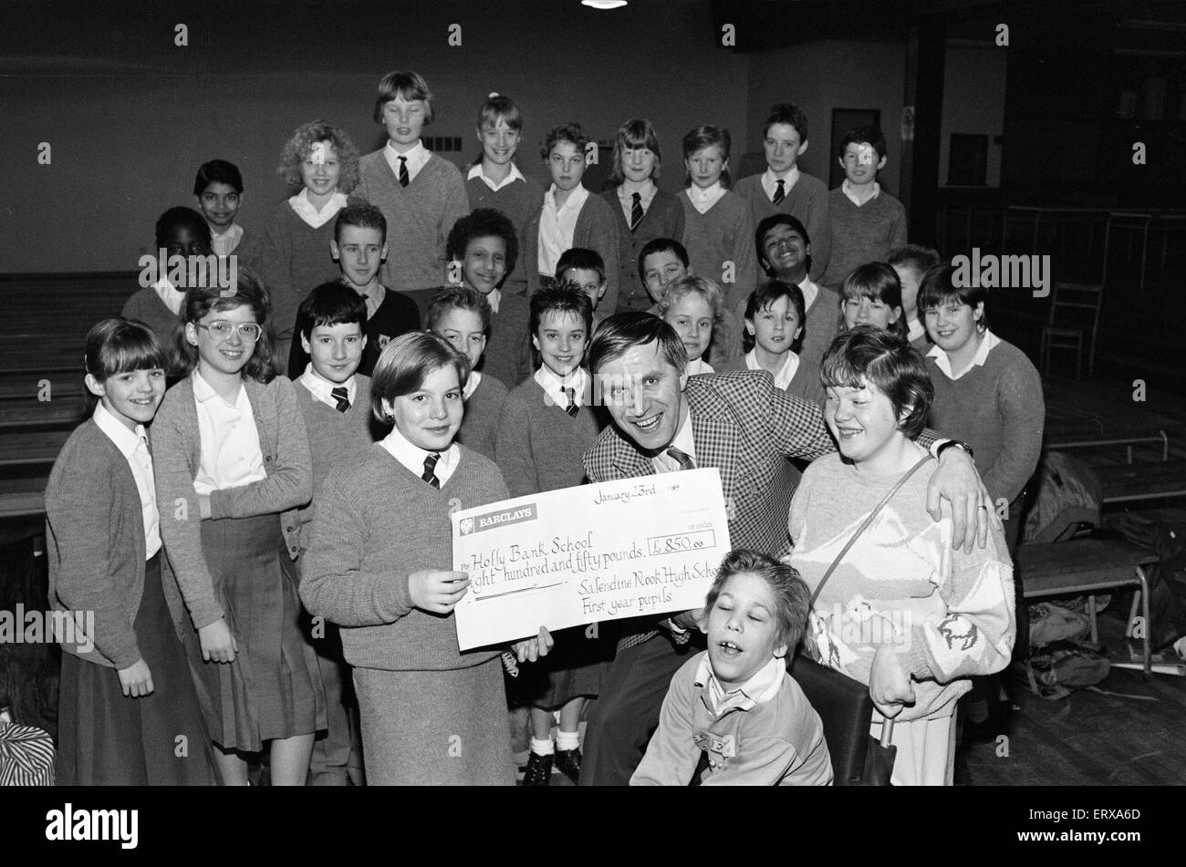 Schüler von Salendine Nook High School präsentieren einen Scheck im Wert von 850 Poounds John Proctor, kommissarischer Leiter der Holly Bank Schule, für ihre neuen Räume in Mirfield, 26. Januar 1989. Stockfoto