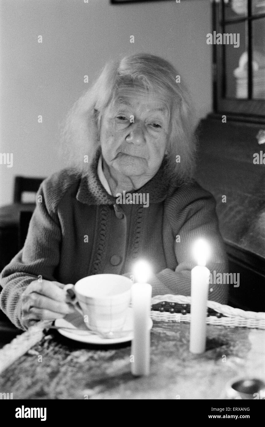 Ältere Frau, eine Tasse Tee trinken, bei Kerzenschein, Perry Barr, Birmingham, 11. Februar 1972. Stockfoto