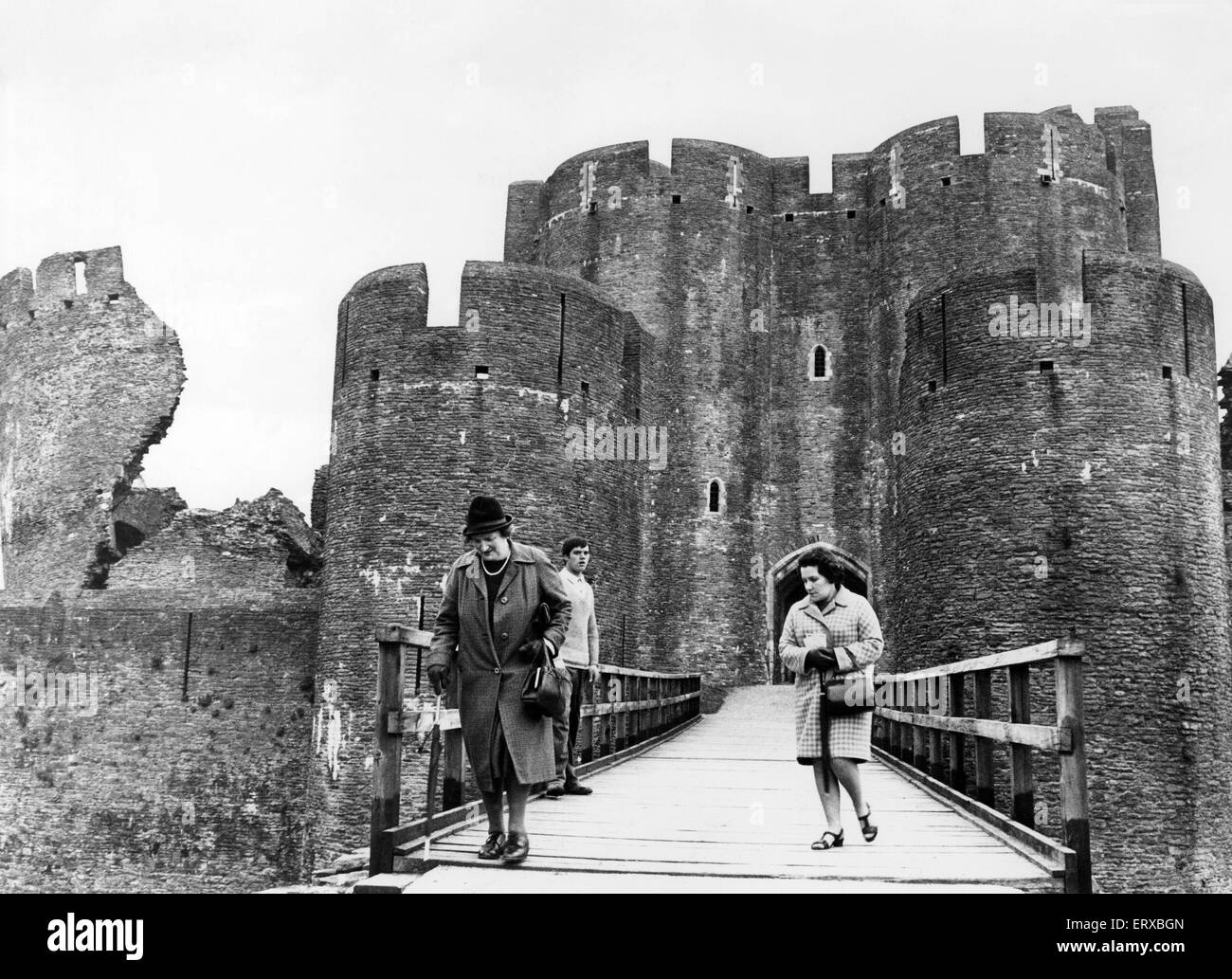 Caerphilly Castle, eine mittelalterliche Festung in Caerphilly in Südwales. 21. Mai 1968. Im Bild, die Burg berühmten Schiefen Turm auf der linken Seite. Zwei Damen gehen über die Brücke auf der Burg nach verbringen einen Nachmittag bereisen Wales die größte Burg. Stockfoto