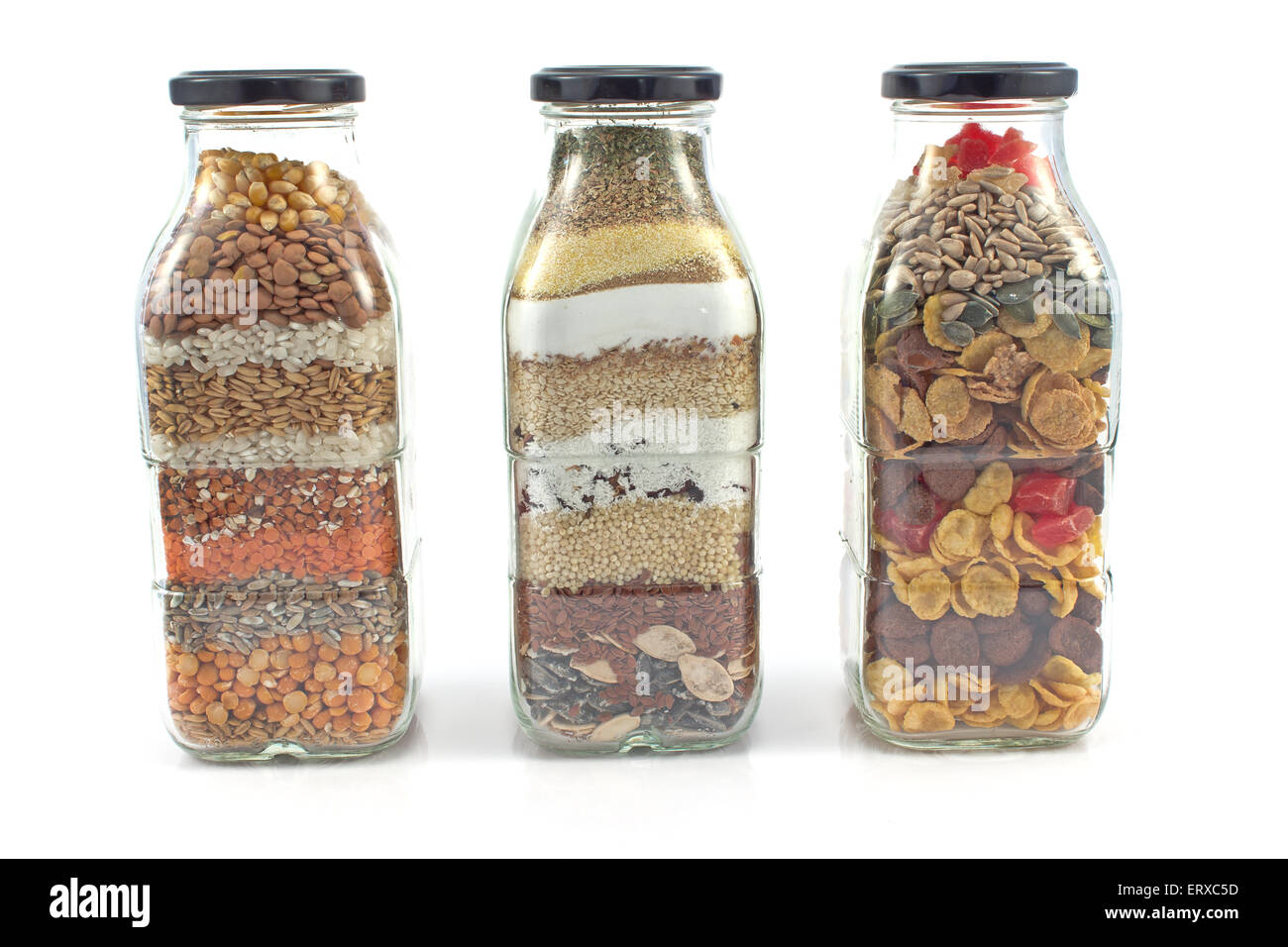 Dekorative Glasflaschen mit Samen isoliert auf weiss Stockfoto