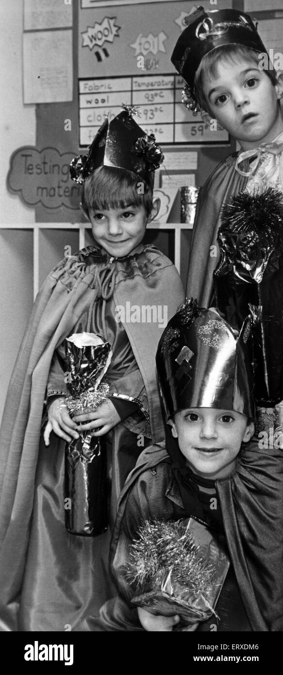 Peeping rund um Bethlehem Stalltür, The Three Wise Men mit Geschenken aus Gold, Weihrauch und Myrrhe für das Jesuskind. Die 5-jährige Pinnell Drillinge aus Pentwyn, Cardiff, Teilnahme an ihre St. Bernadette R C Schule Krippenspiel. Sie sind Anthony (oben), Richard (links) und Joseph (unten). 15. November 1989. Stockfoto