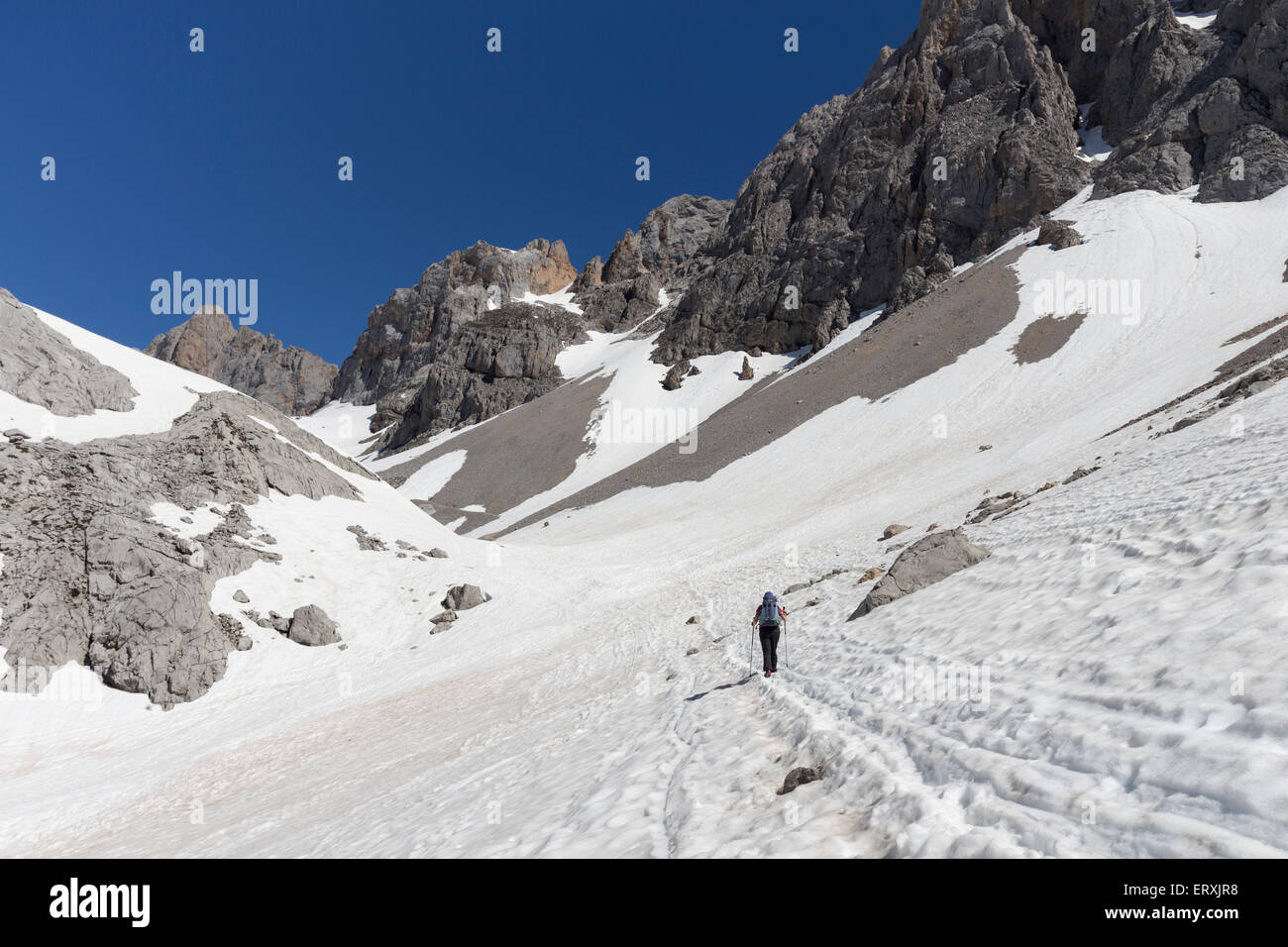Wanderer durchqueren Frühjahr Schneefelder an der La Vueltona (PR-23) Pfad Picos de Europa Cordillera Cantabrica Spanien Stockfoto