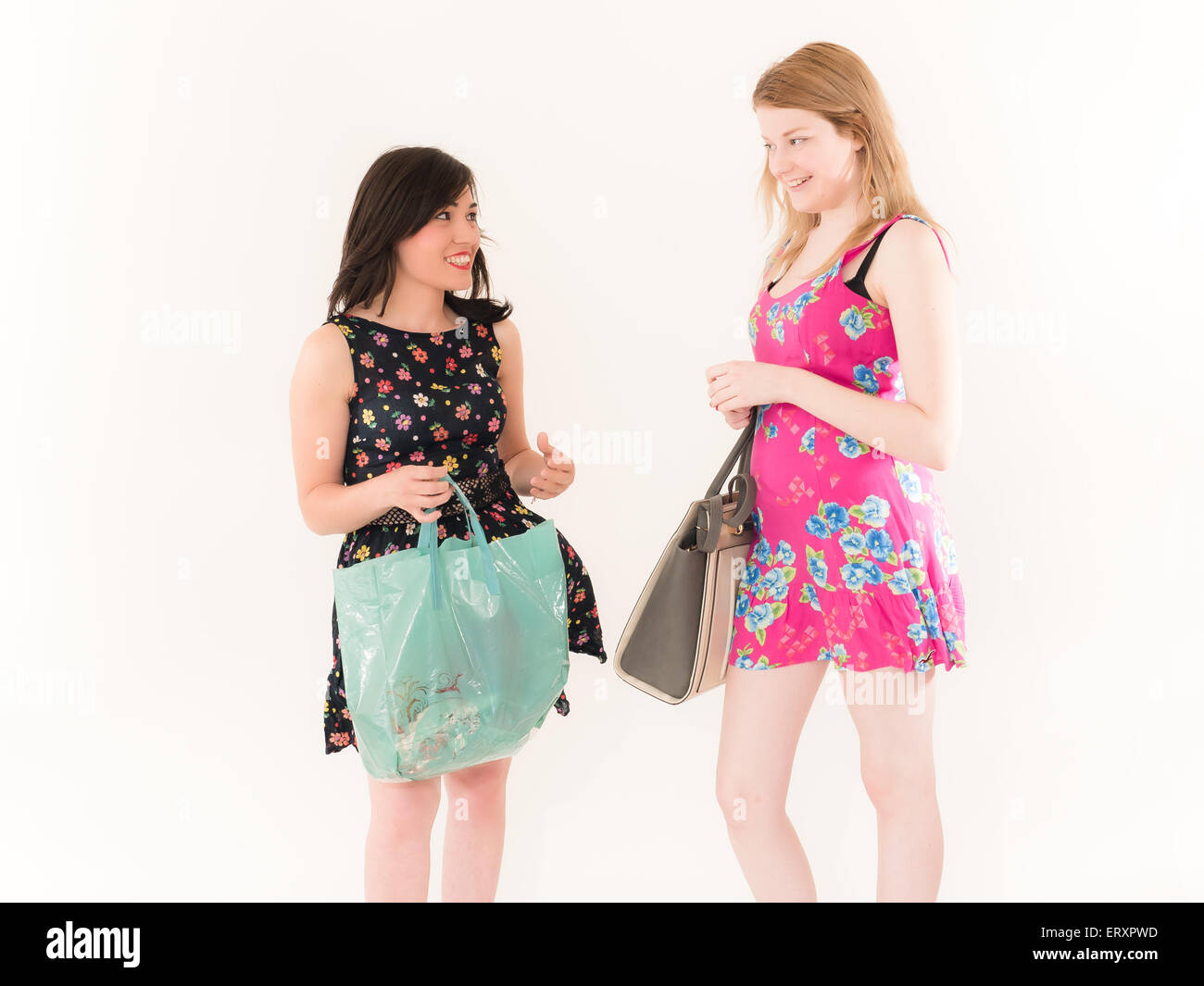 Zwei Shopping Frauen sahen einander isoliert auf weißem Hintergrund Stockfoto
