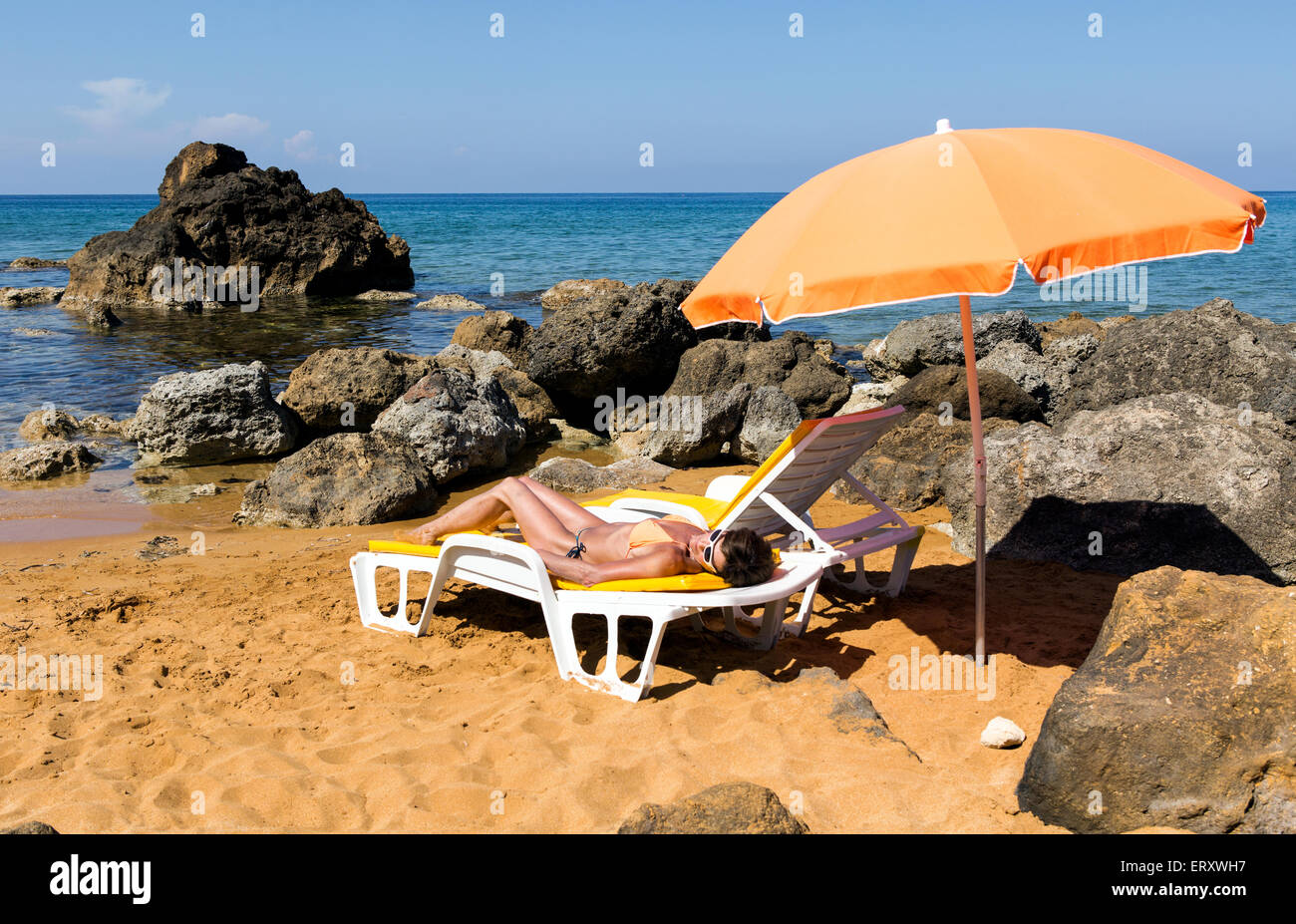 Frau Sonnenbaden auf einem Beachbed und Sonnenschirm In San Blas Bay