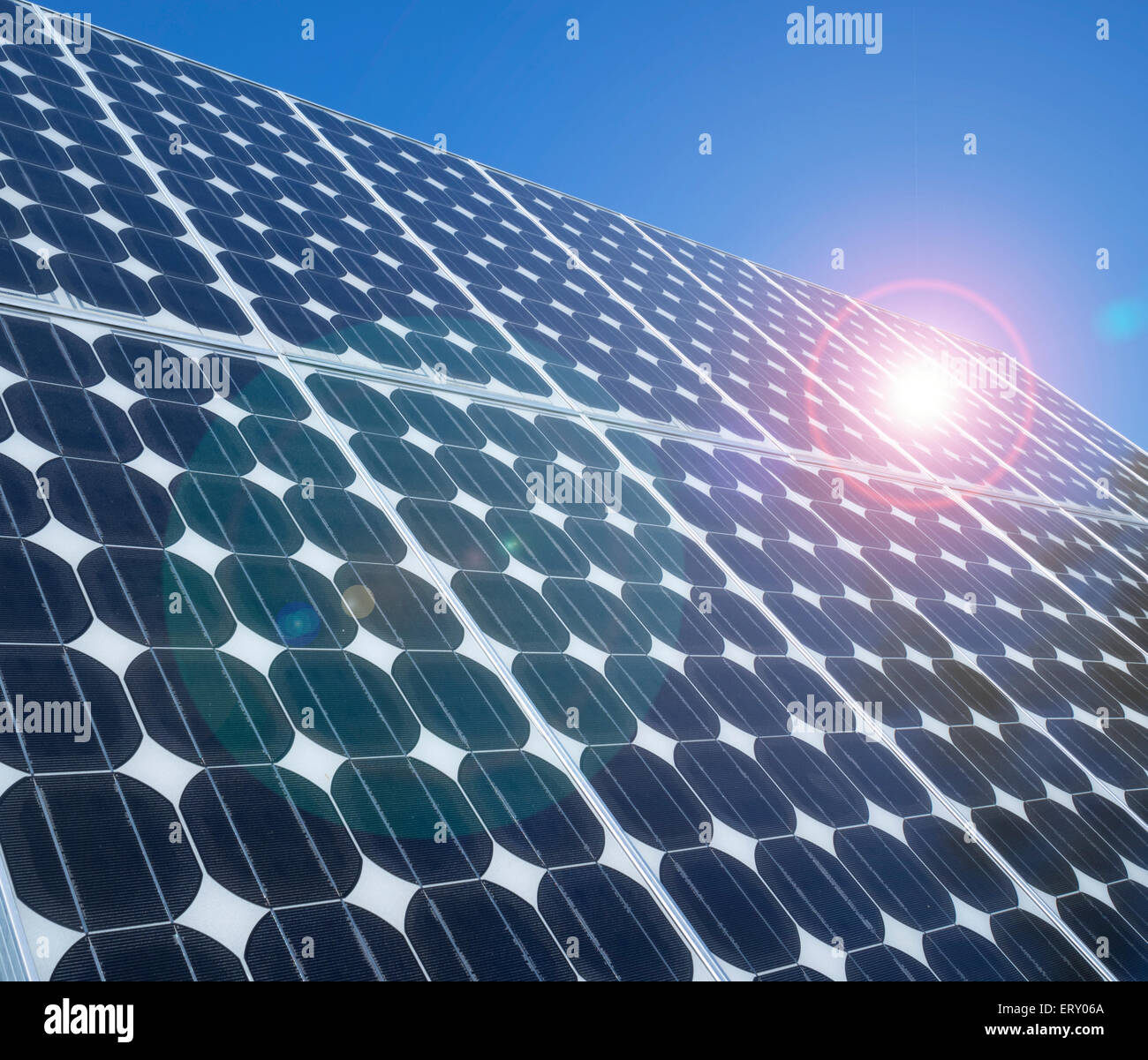 Photovoltaische Zellen array Close up Blue lens flare Sonnenlicht Reflexion über Sonnenkollektoren Nachhaltige umweltfreundliche grüne Energie Zusammenfassung Hintergrund Stockfoto