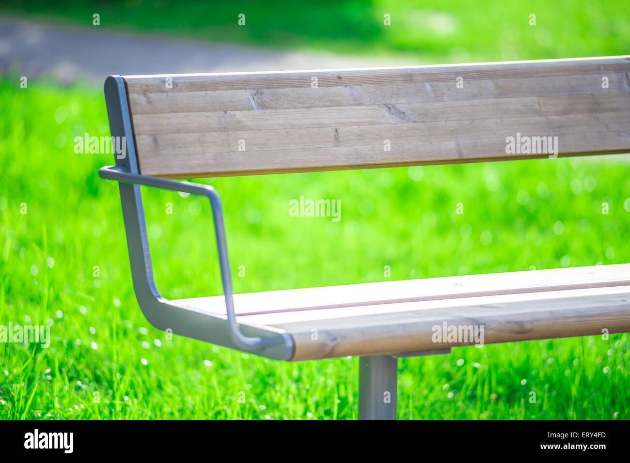 Nahaufnahme einer hölzerne Parkbank steht auf dem grünen Rasen Stockfoto