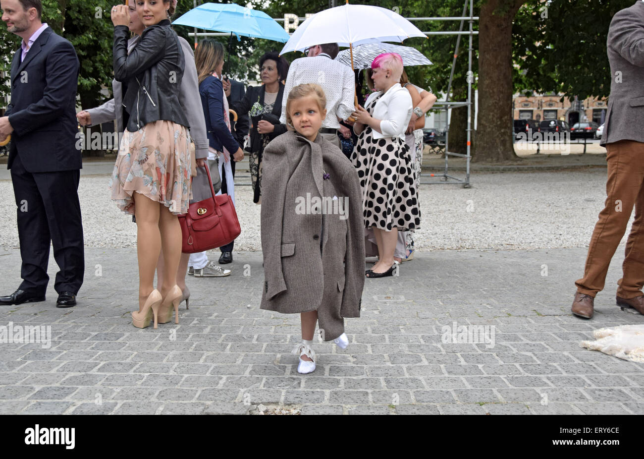 Britische Mädchen tragen ihres Vaters Mantel bei einer Hochzeit in Brügge, Belgien Stockfoto