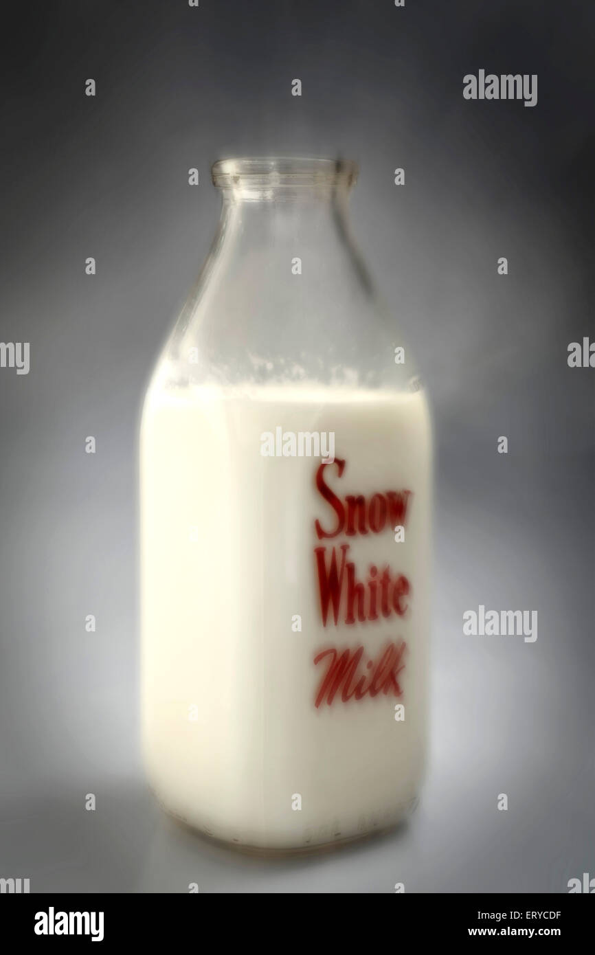Milch in Glasflasche auf grauem Hintergrund Stockfoto
