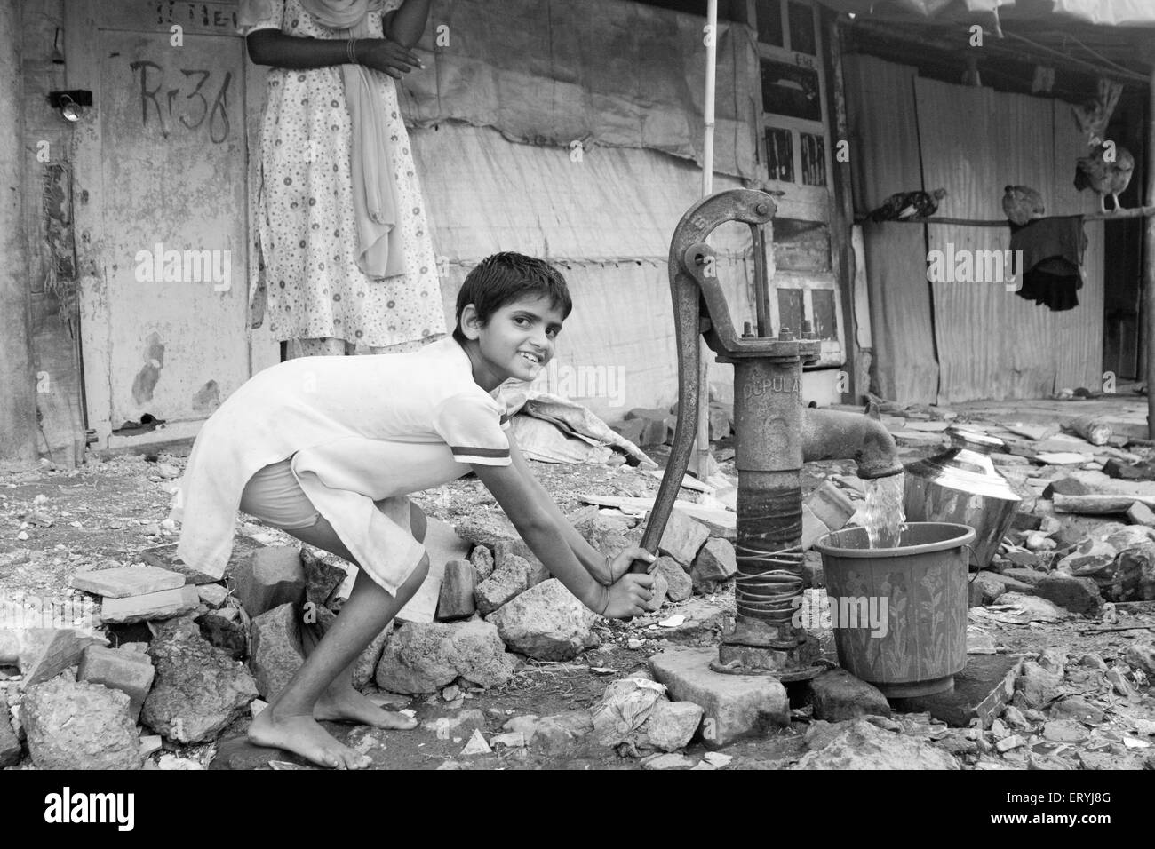 Mädchen, die Wasserpumpen aus Handpumpe; Malvani Slum; Malad; Bombay Mumbai; Maharashtra; Indien nicht Herr Stockfoto