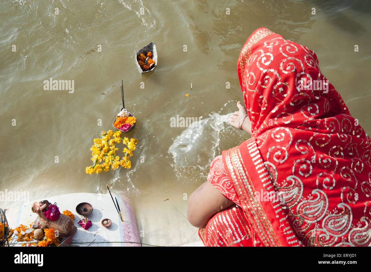 Frau schweben Papier Boot und blühen in Ganges Fluß in Uttar Pradesh, Indien Stockfoto