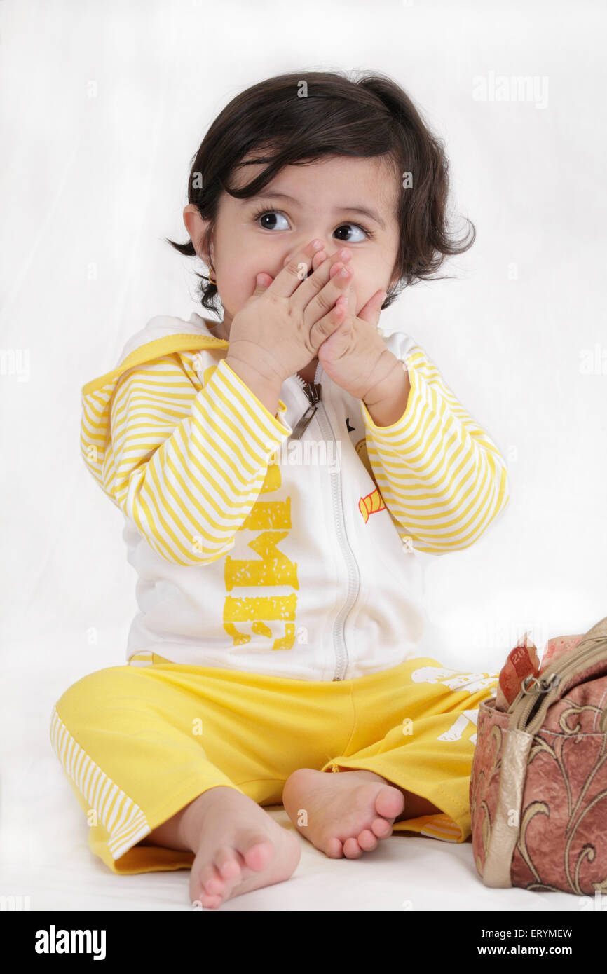 Fünfzehn Monate altes Babymädchen posiert beide Hände am Mund Herr #743S Stockfoto