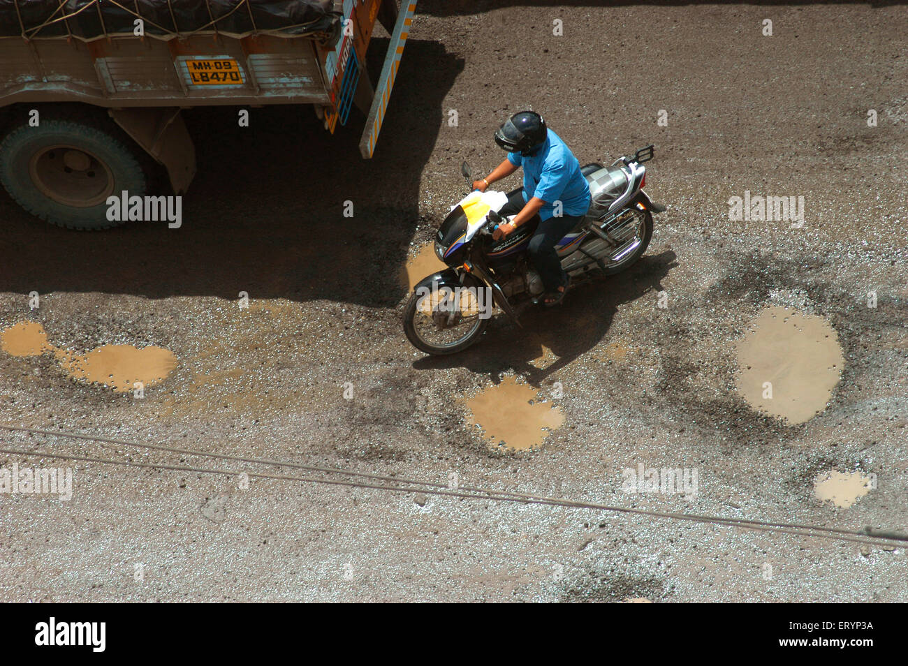 Zwei Räder und schwere Fahrzeuge nehmen gefährliche Reise Monsun auf Ghodbunder Straße in Thane; Maharashtra; Indien Stockfoto