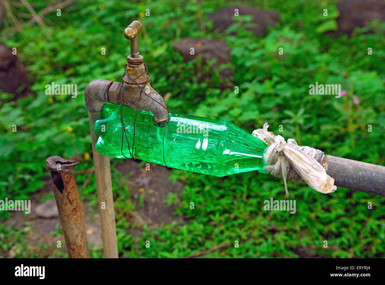 Kunststoff Wasserflasche zum Verbinden von Hahn und Rohr Bombay Mumbai Maharashtra Indien Asien Idee indische geniale Erfindung ungewöhnlich seltsam lustig Asiatisch Stockfoto