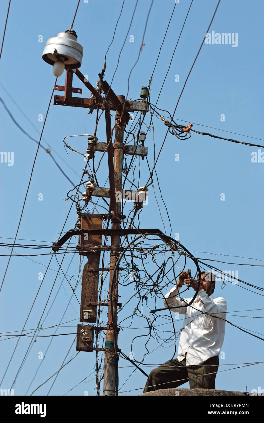 Elektriker arbeiten an verworrenen Stromdrähten, Stromdiebstahl, Malegaon, Maharashtra, Indien, Asien Stockfoto