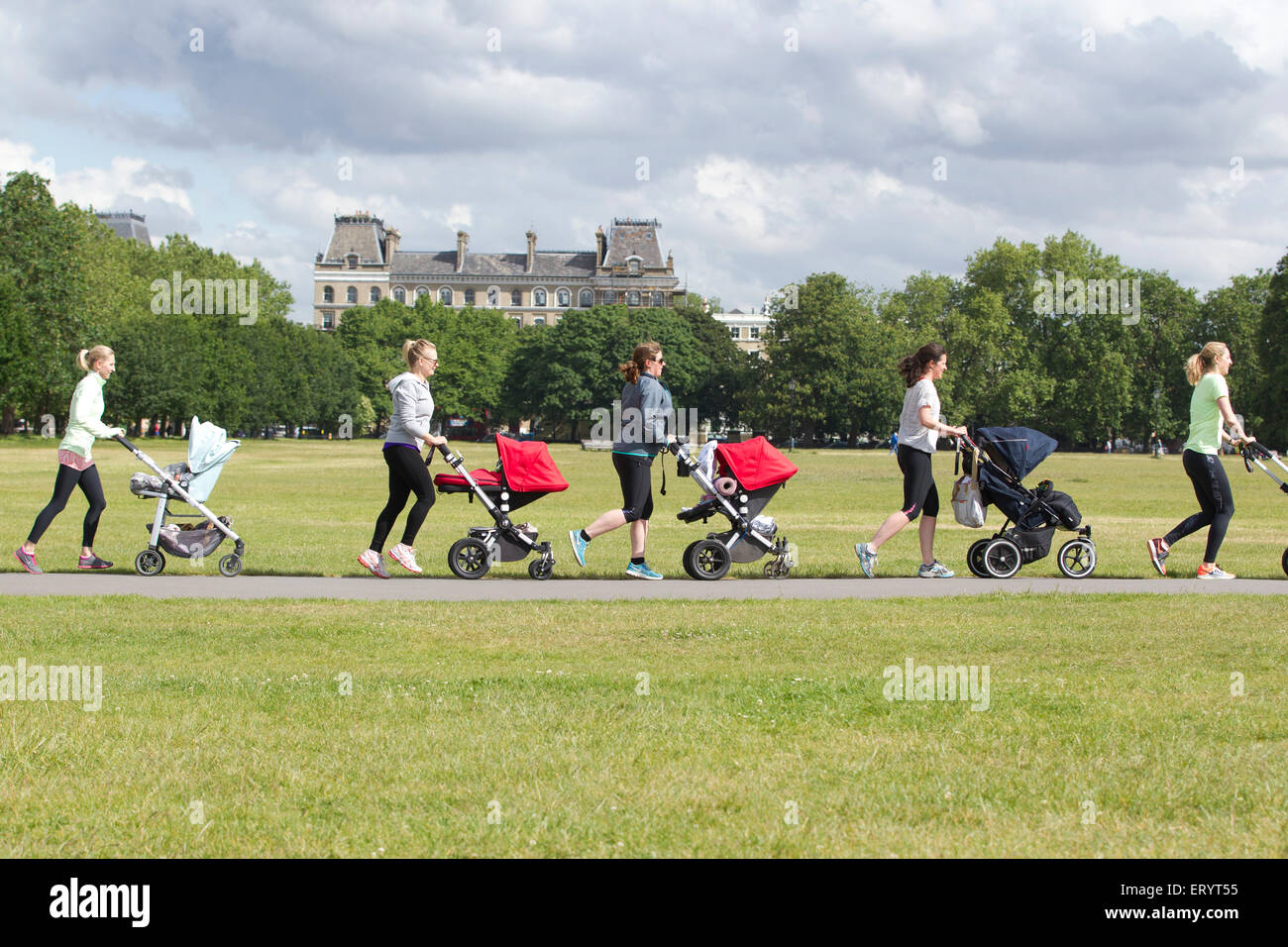 Mutter nimmt eine Übung mit Baby und Kleinkind in ihrer Buggys in einem Park in London, England, UK Stockfoto