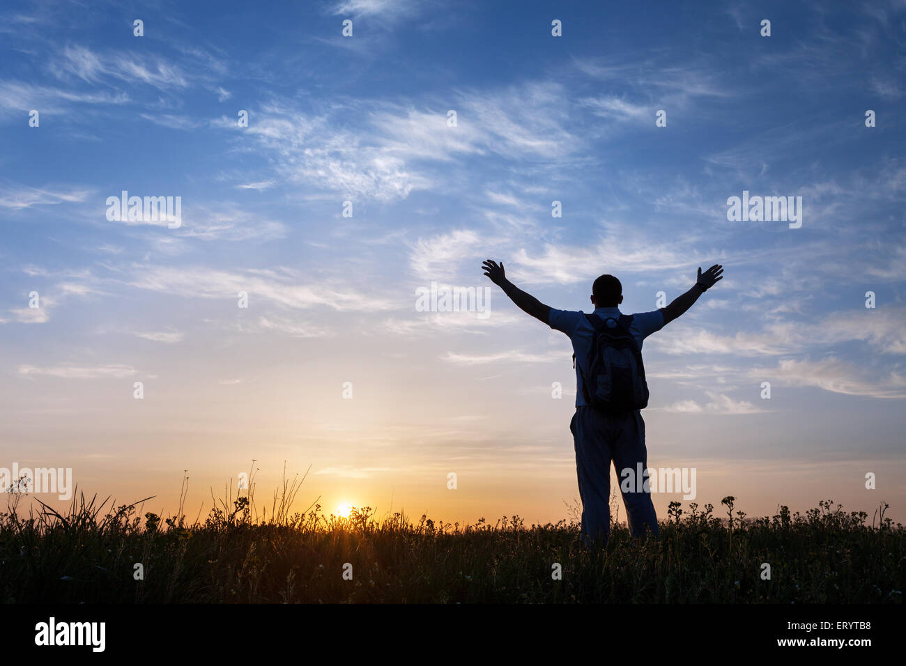 Silhouette des Mannes mit Armen angehoben auf und schönen Himmel. Element des Designs. Sommer Sonnenuntergang. Hintergrund Stockfoto