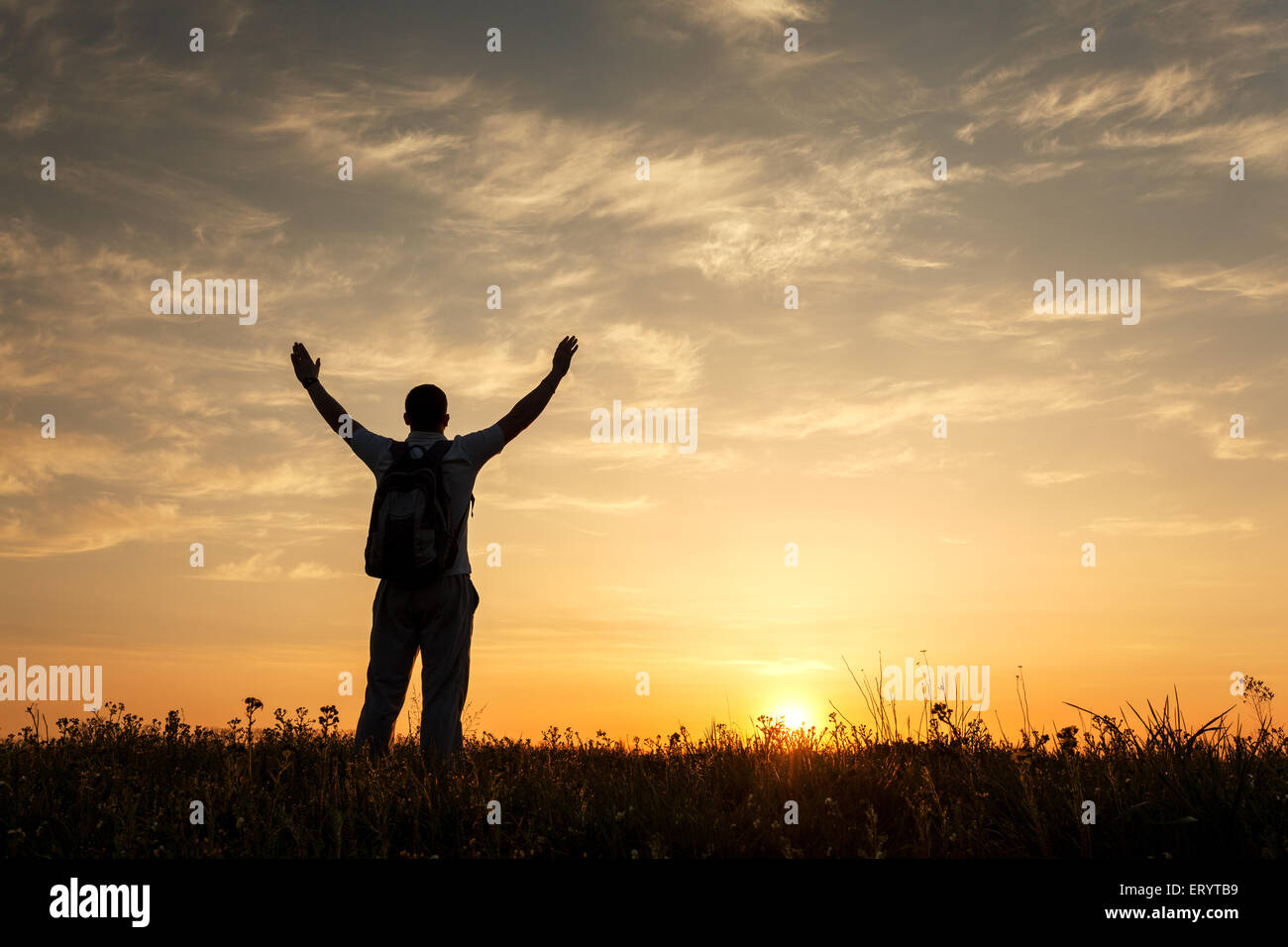 Silhouette des Mannes mit Armen angehoben auf und schönen Himmel. Element des Designs. Sommer Sonnenuntergang. Hintergrund Stockfoto