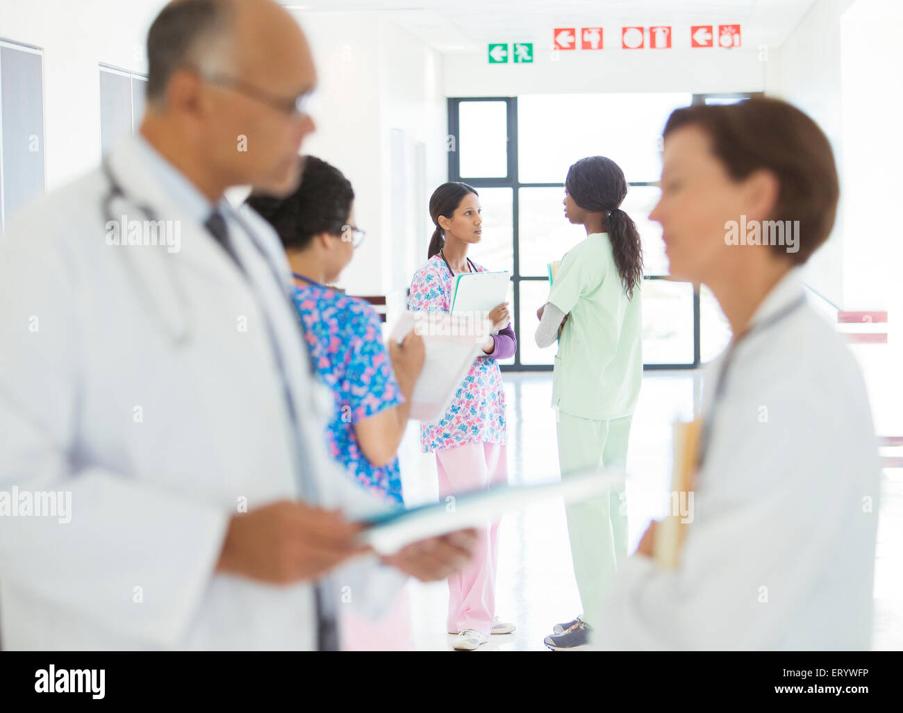 Ärzte und Krankenschwestern im Krankenhausflur sprechen Stockfoto