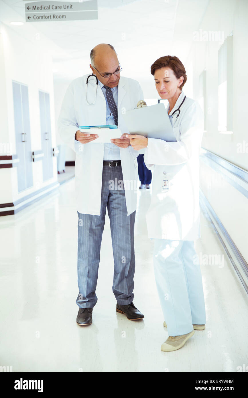 Ärzte mit medizinischen Diagrammen im Krankenhausflur Beratung Stockfoto