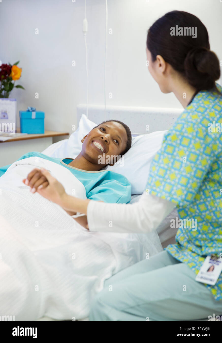 Krankenschwester, halten Hand lächelnd Patienten im Krankenzimmer Stockfoto