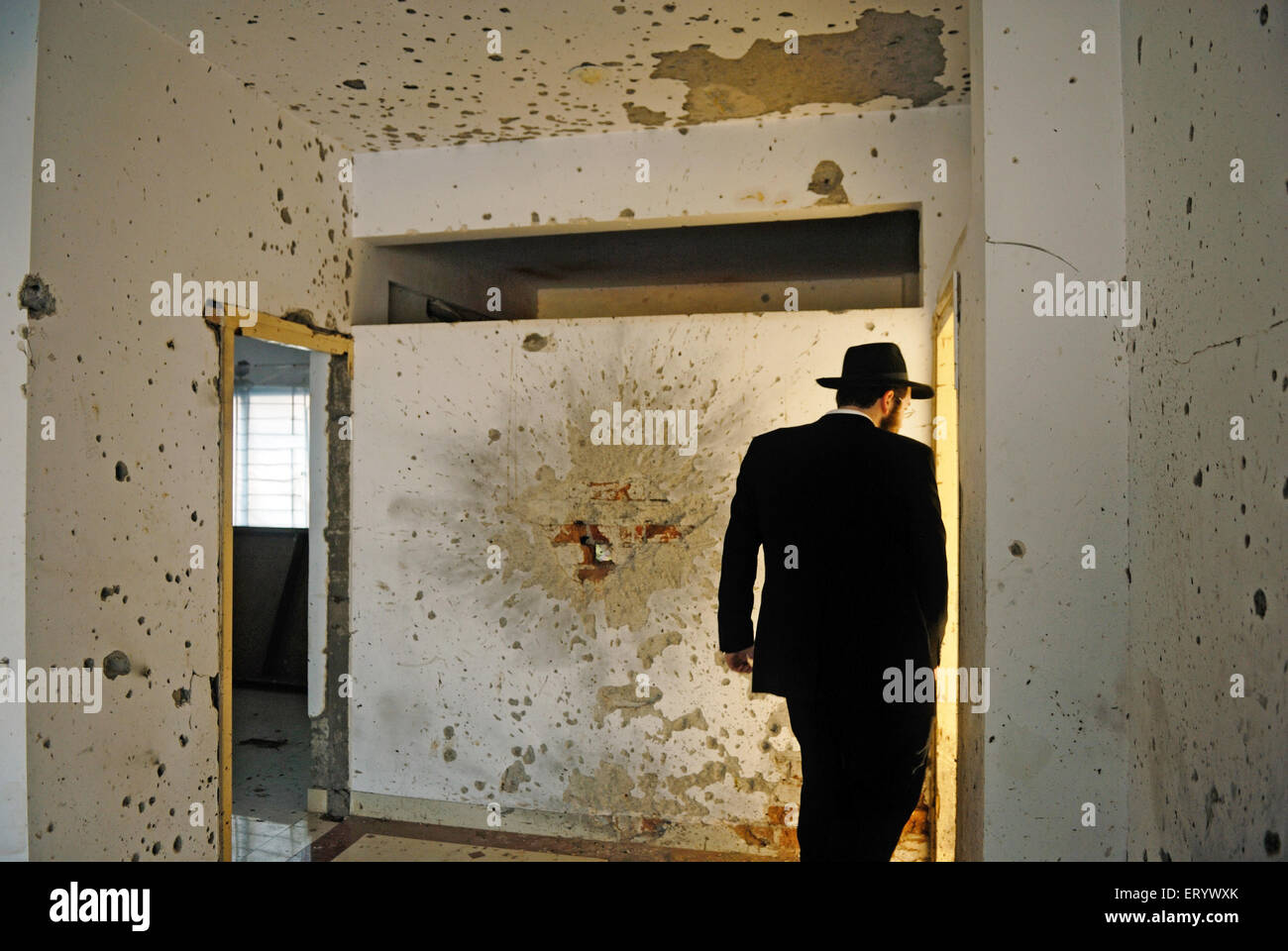 Orthodoxer Jude inspiziert beschädigte Wände in Granate sprengen und Kugel Markierungen im Nariman House; Bombay Mumbai; Maharashtra; Indien Stockfoto