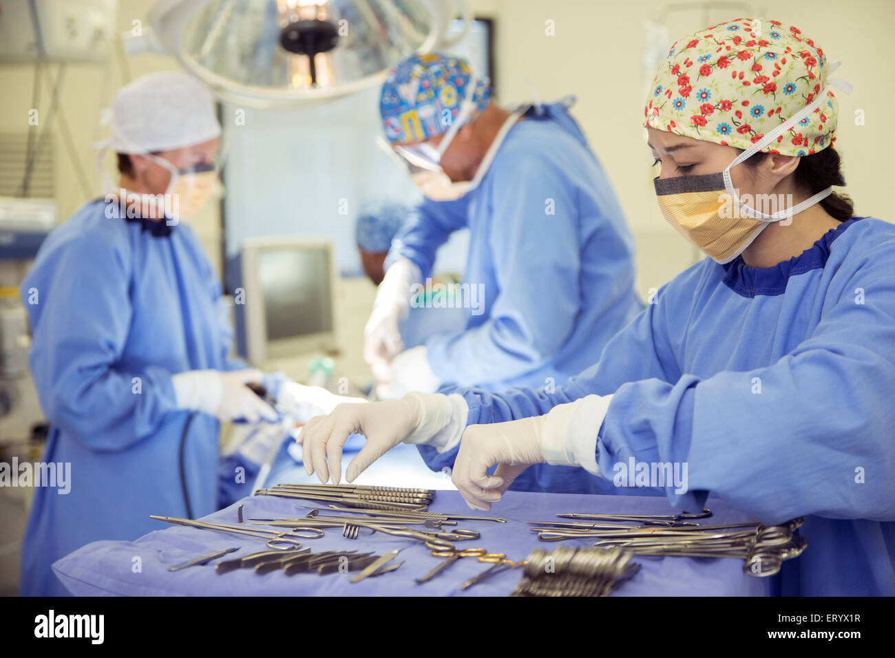 Facharzt für Chirurgie am Tablett chirurgische Schere im OP-Saal Stockfoto