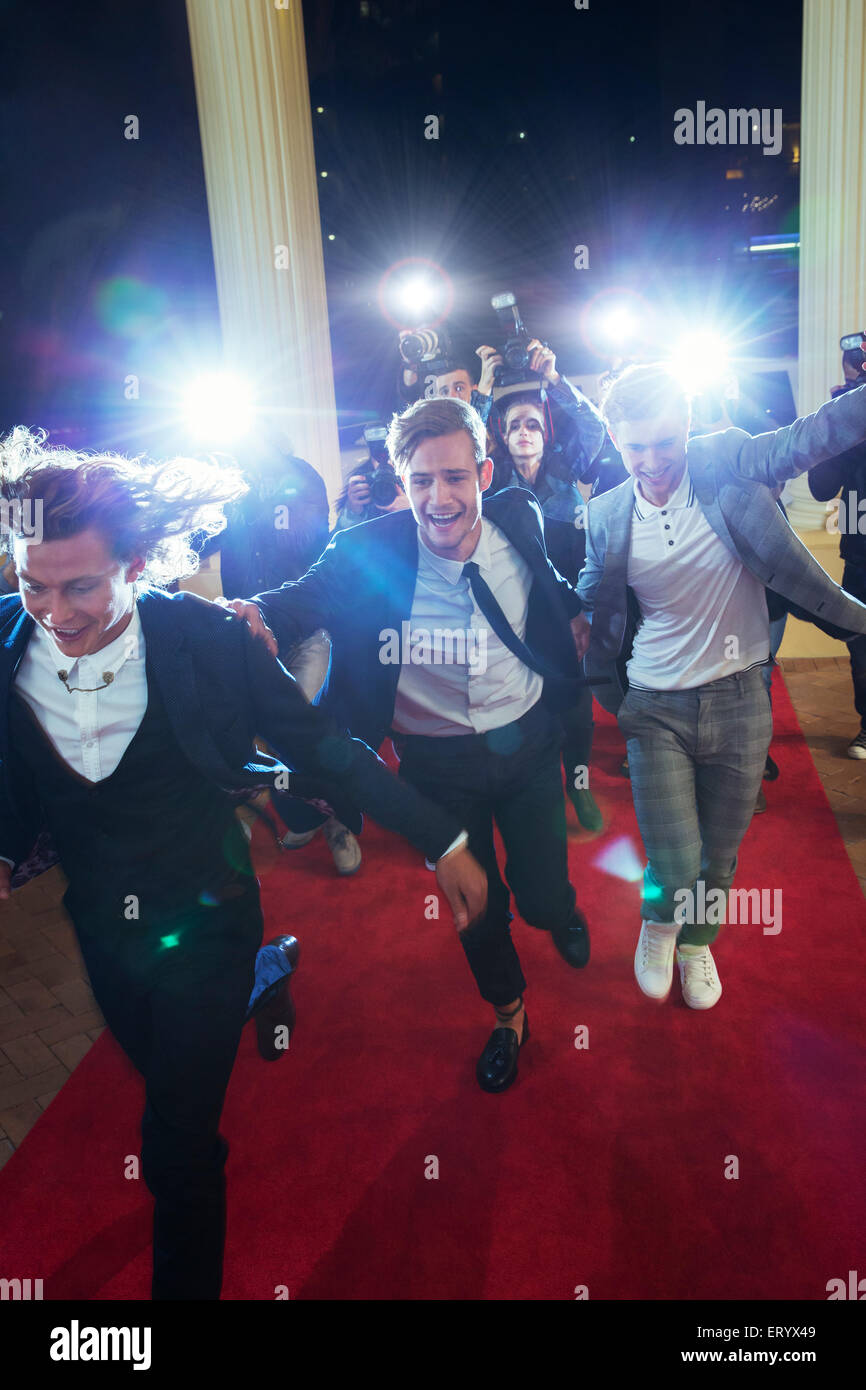 Prominente ankommen und von Paparazzi-Fotografen am roten Teppich Stockfoto