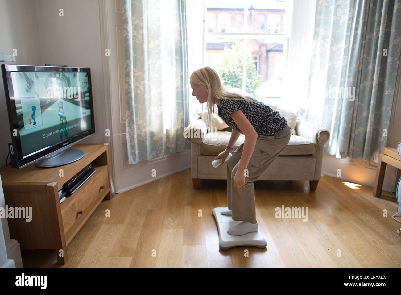 11 Jahre alten Mädchen spielen Wii Spielkonsole zu Hause im Wohnzimmer während der langen Schulferien Sommer Urlaub, London, UK Stockfoto