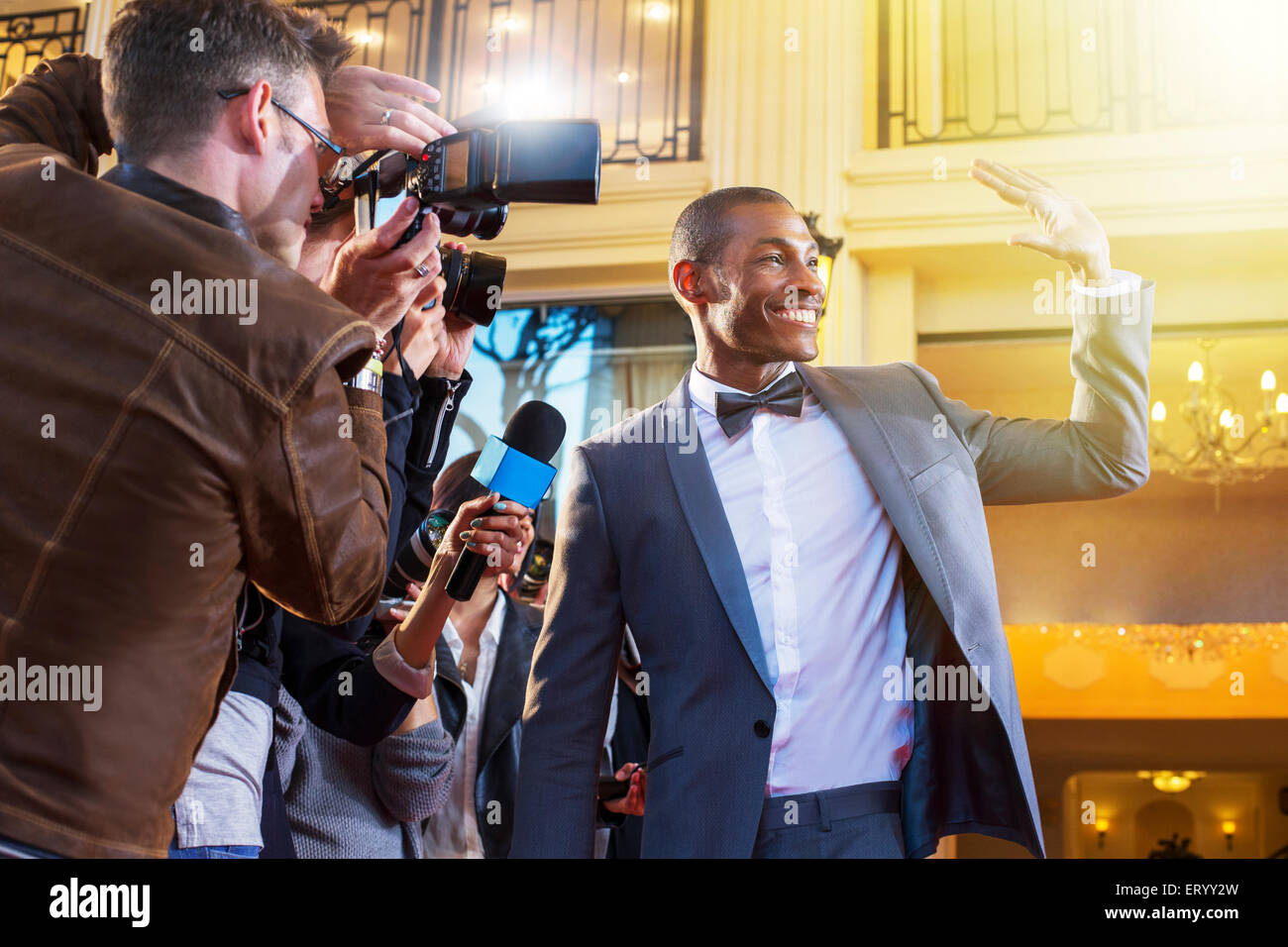 Celebrity winken und fotografiert von Paparazzi-Fotografen Stockfoto