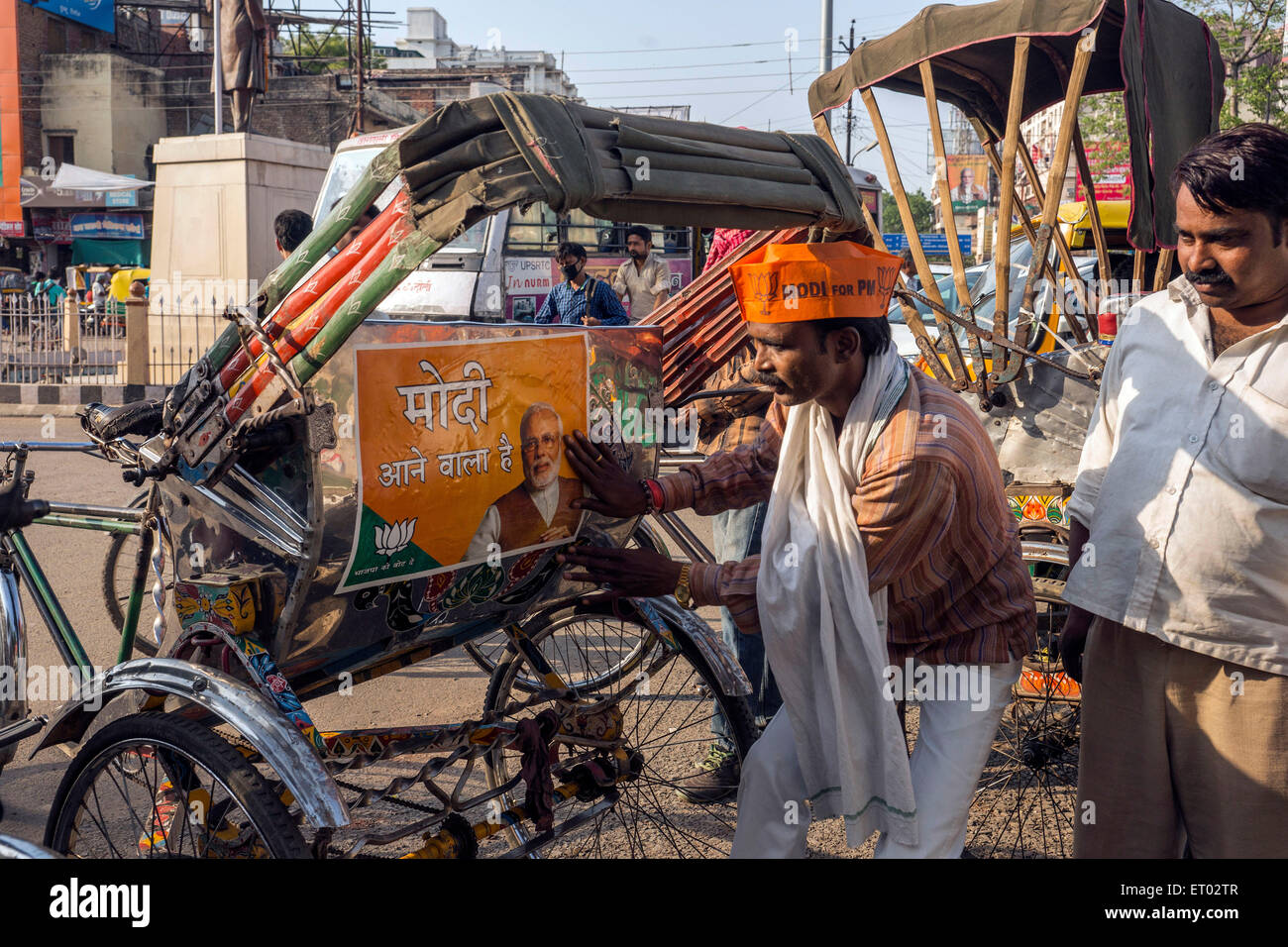 Mann kleben Poster auf Fahrradrikscha Varanasi Uttar Pradesh Indien Asien Stockfoto