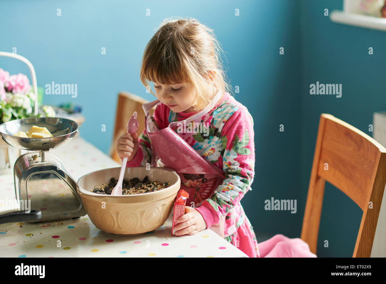 Neugierige Mädchen Backen mit Rührschüssel in Küche Stockfoto