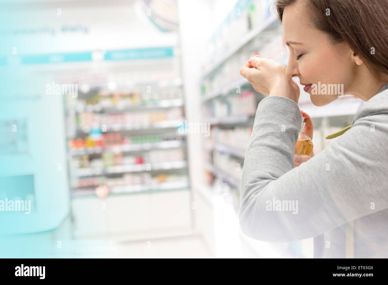 Frau versucht auf Parfüm in Apotheke Stockfoto