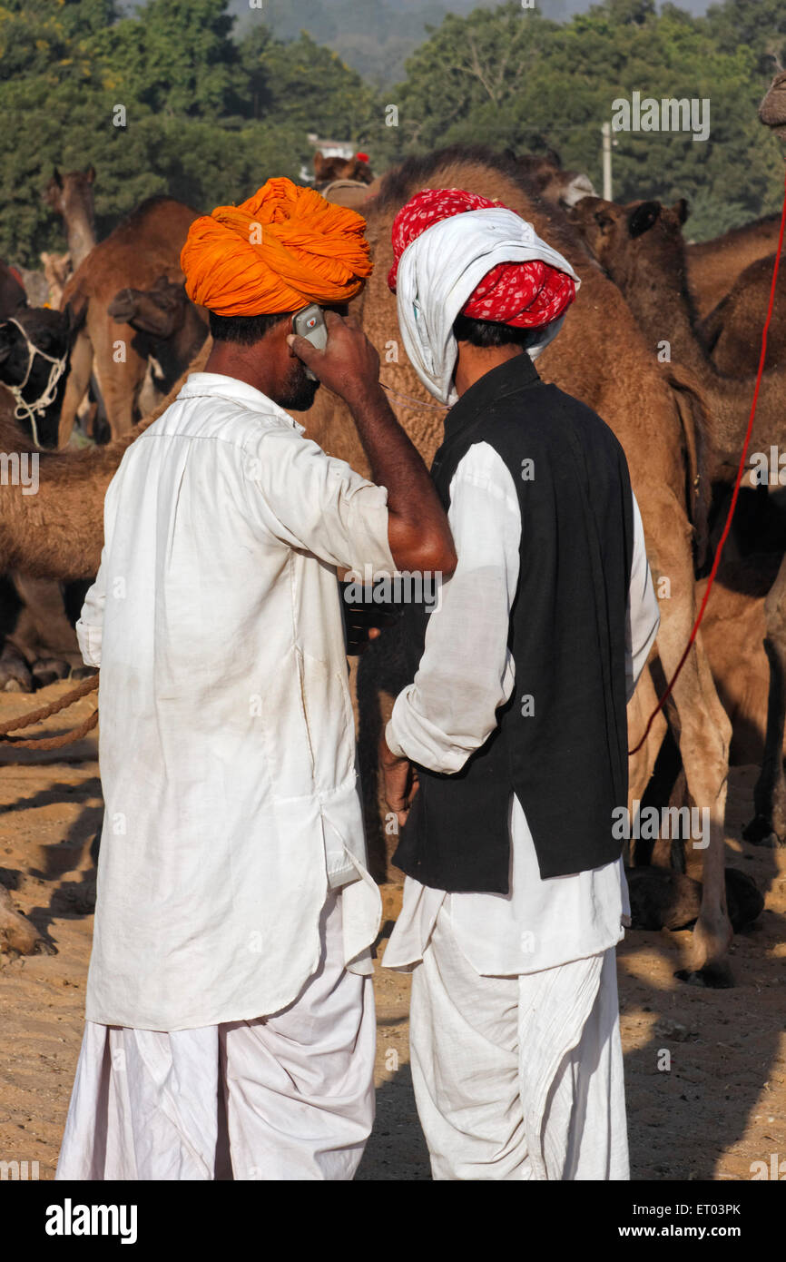 Dorfbewohner mit einem Handy in Pushkar Mela; Rajasthan; Indien Stockfoto