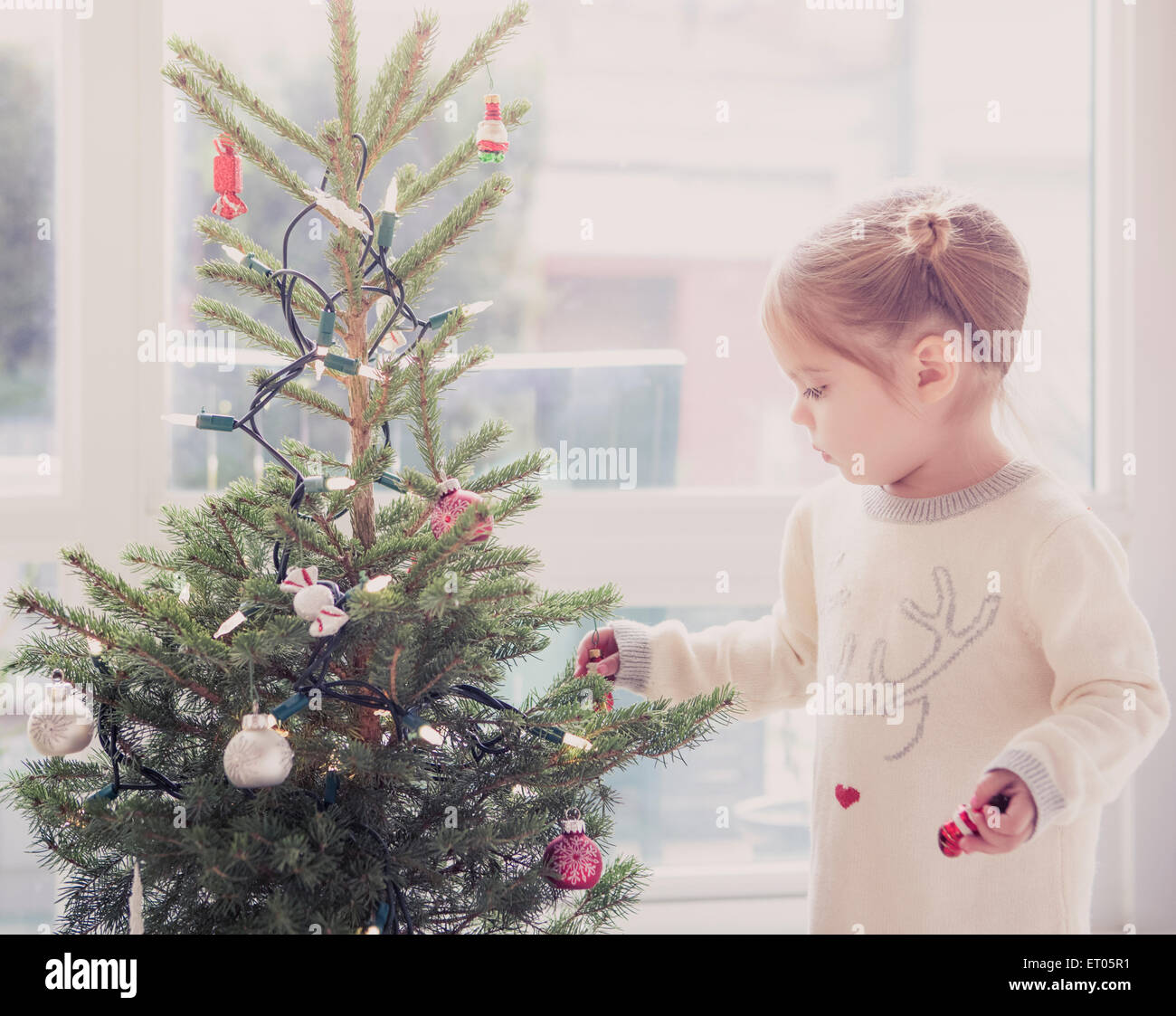 Mädchen schmücken kleine Weihnachtsbaum Stockfoto