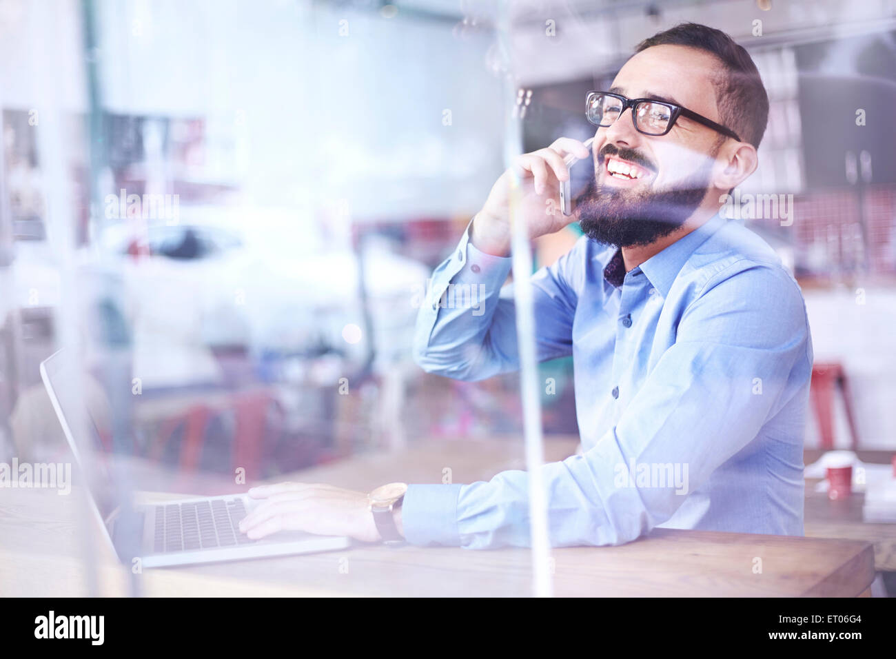 Geschäftsmann, reden über Handy am Laptop im Café Fenster lachen Stockfoto