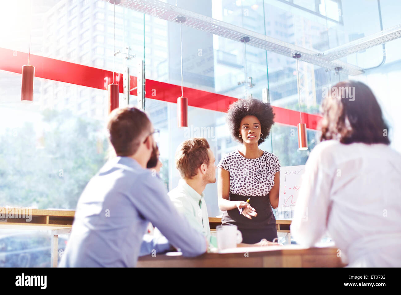 Geschäftsfrau, die führende Treffen im sonnigen Büro Stockfoto