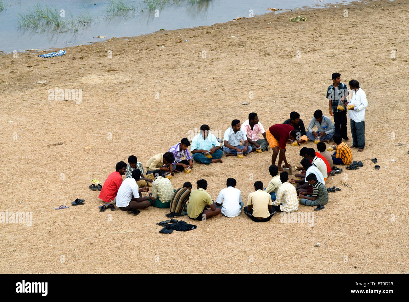Picknick Männer sitzen essen, bhavani Fluss; Dharapuram; Tirupur Bezirk, Tamil Nadu; Indien, asien Stockfoto