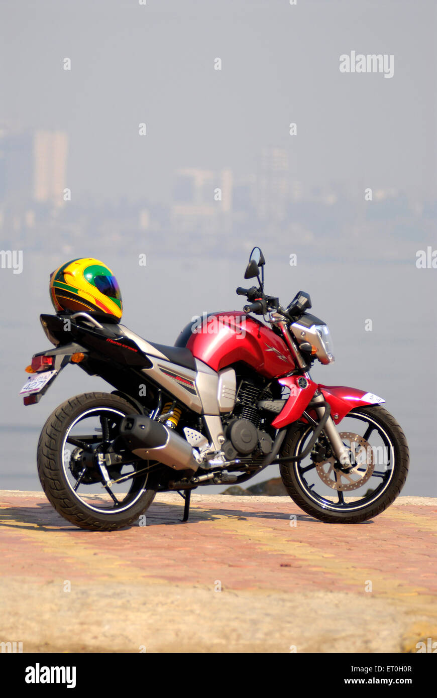 Motorrad Yamaha FZ Red 150cc Sportmotorrad mit farbenfrohem Helm Stockfoto
