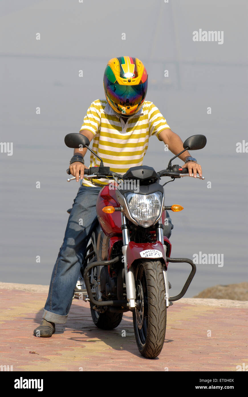 Kleiner Junge im Helm Reiten rot gefärbt Yamaha Fz Motorrad 150ccm Sport Bike; Bombay Mumbai; Maharashtra; Indien Herr #721 Stockfoto