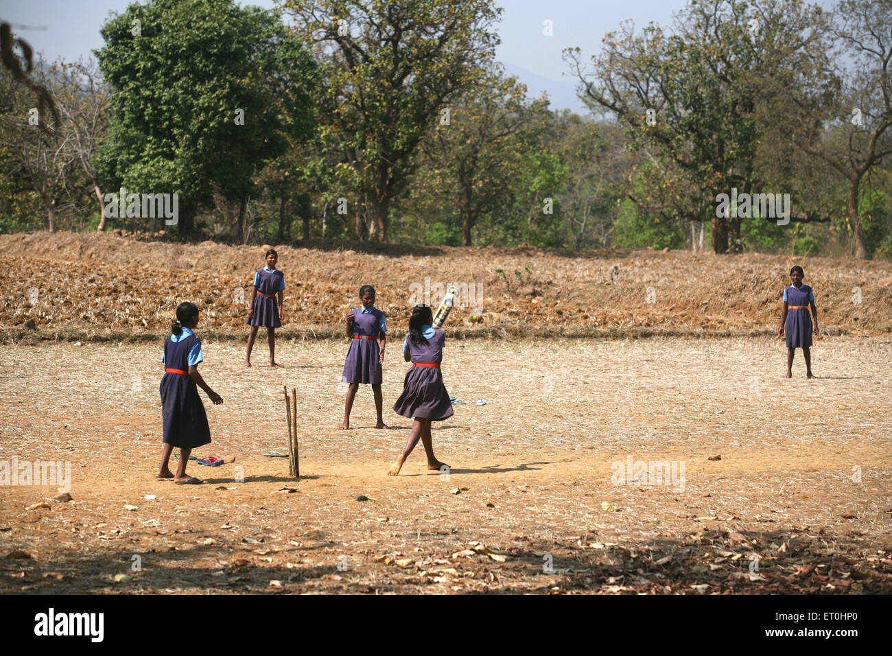 School Mädchen spielen Kricket in der Uniform im trockenen Felder in Jharkhand Indien Stockfoto