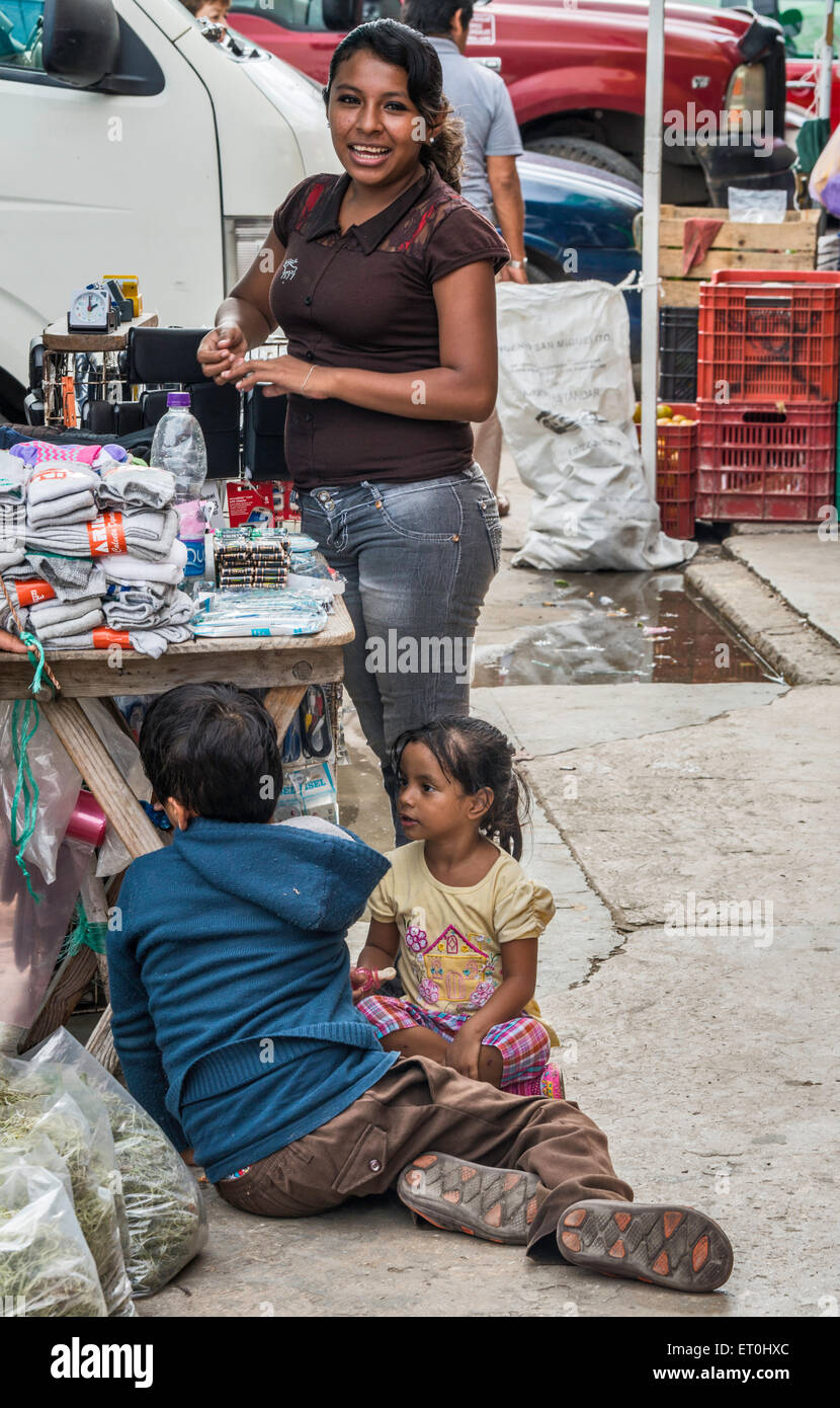 Junge Frau, die Kinder am Markt stall auf Calle 22, Straße in Ciudad del Carmen, Bundesstaat Campeche, Mexiko Stockfoto