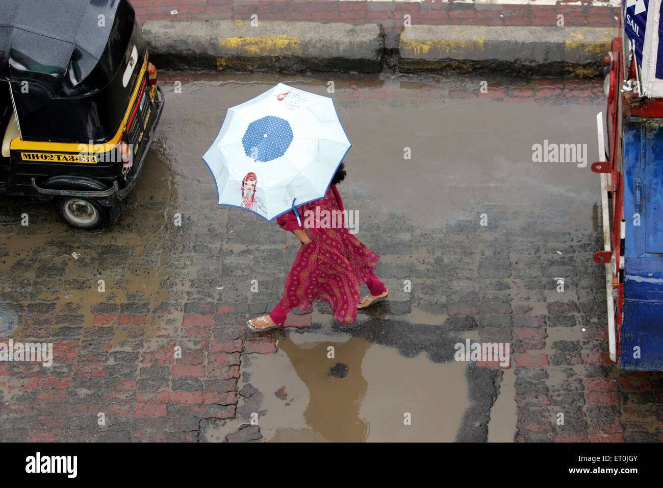 Ein Mädchen zu Fuß durch Regen Wasser mit Regenschirm in Bandra; Bombay Mumbai; Maharashtra; Indien Stockfoto