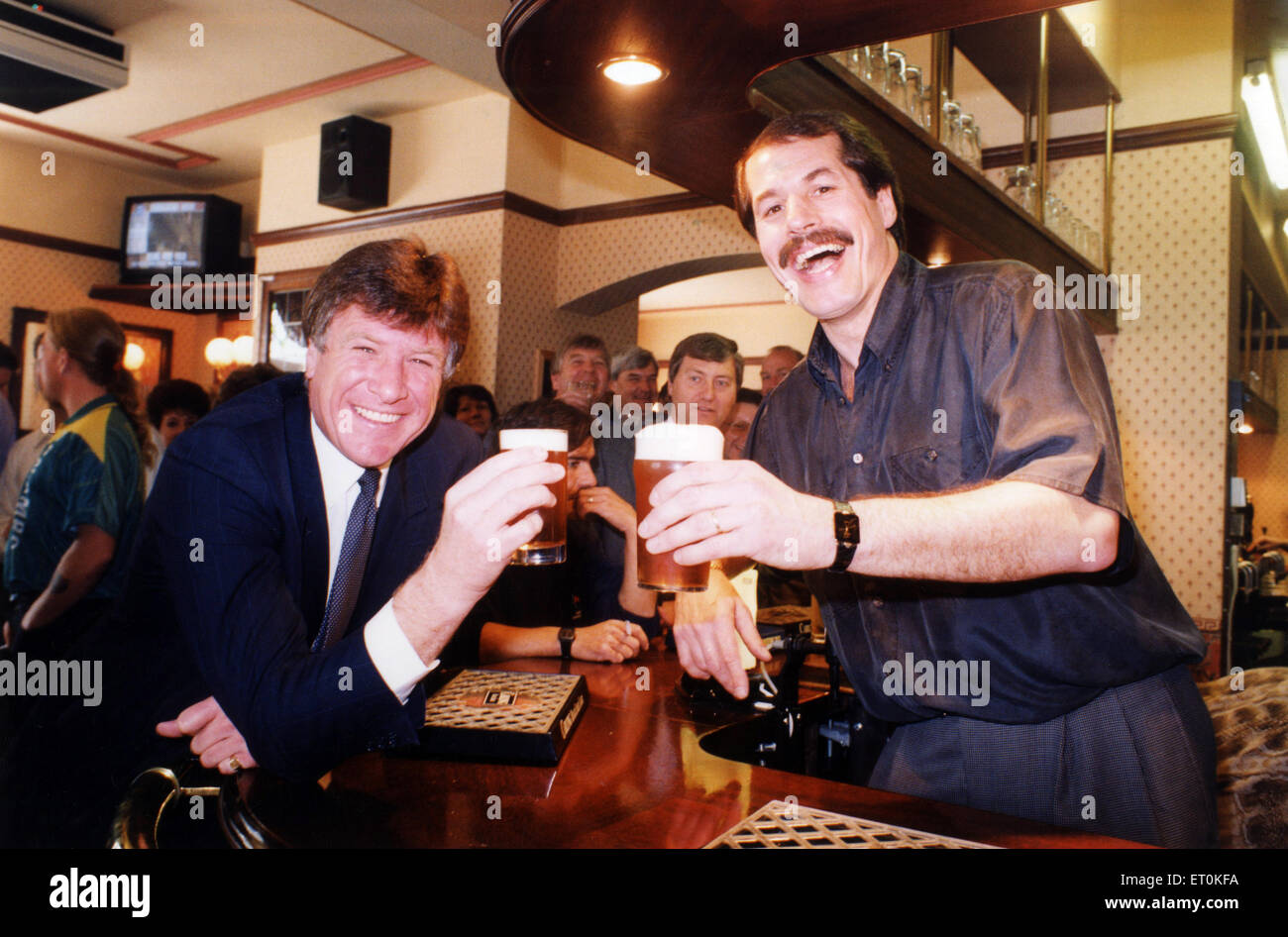 Emlyn Hughes mit Jim Holton, Vermieter von The Hirsch, Bishop Street, Coventry, heben ein Glas in die Zukunft des renovierten Pub, Coventry City Centre, 7. Mai 1992. Stockfoto