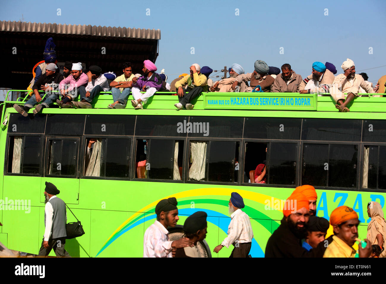 Menschen, die unterwegs auf dem Dach des Busses in Punjab; Indien Stockfoto
