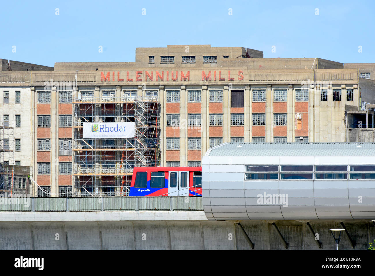 DLR-Zug fährt Pontoon Dock Station mit redundanten Spillers Millennium Mühlen Gebäudes über Arbeiten zur Sanierung begonnen Stockfoto