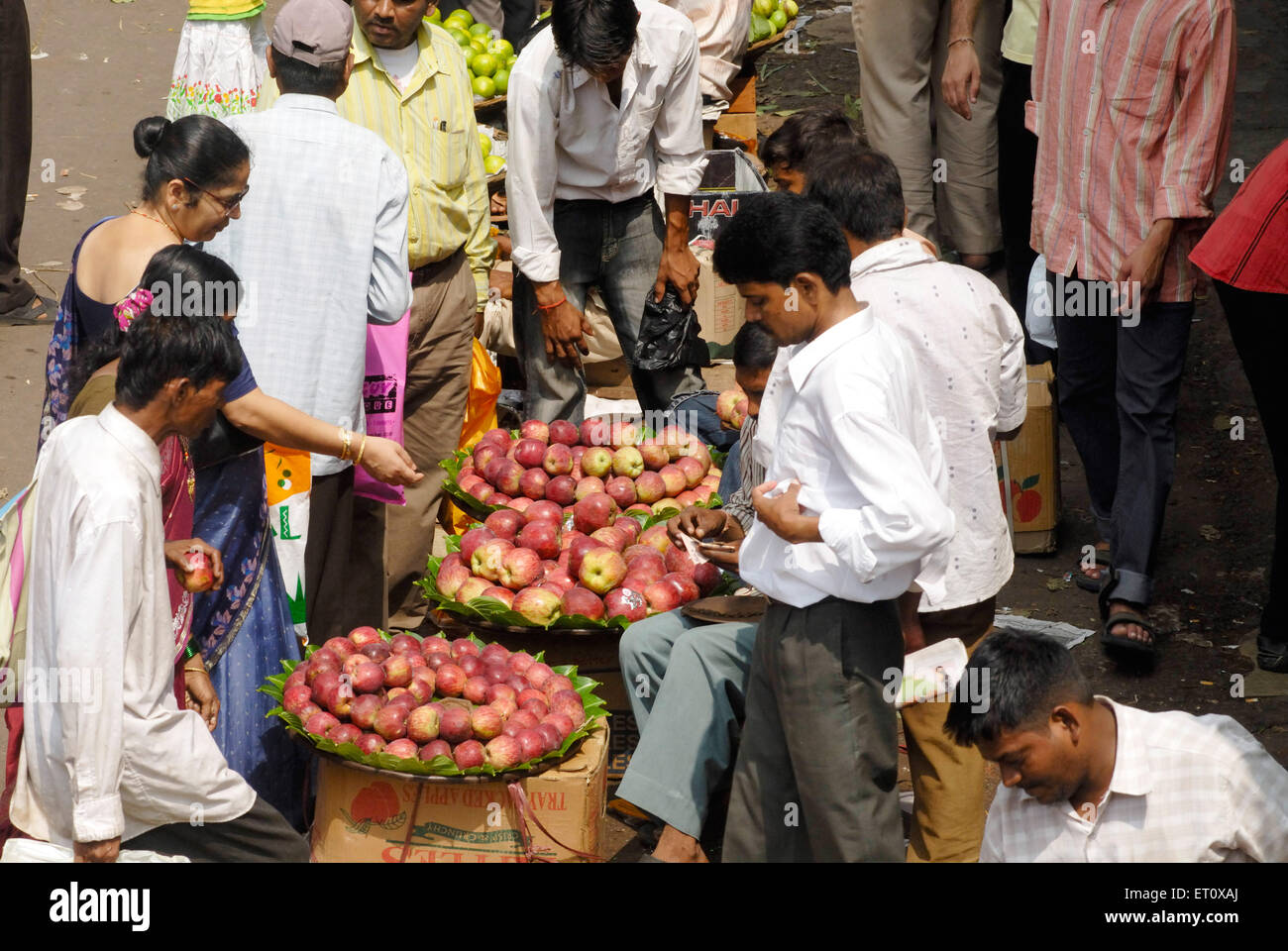 Männer und Frauen, die Äpfel von am Straßenrand fliegenden Händlern kaufen; Ganapati Festival Publikum bei Dadar; Bombay Mumbai; Maharashtra; Indien Stockfoto