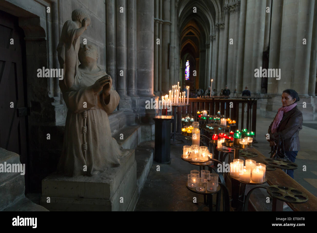 Reims, Frankreich, Kerzen vor einer Skulptur eines Heiligen in der Kathedrale Notre-Dame Stockfoto