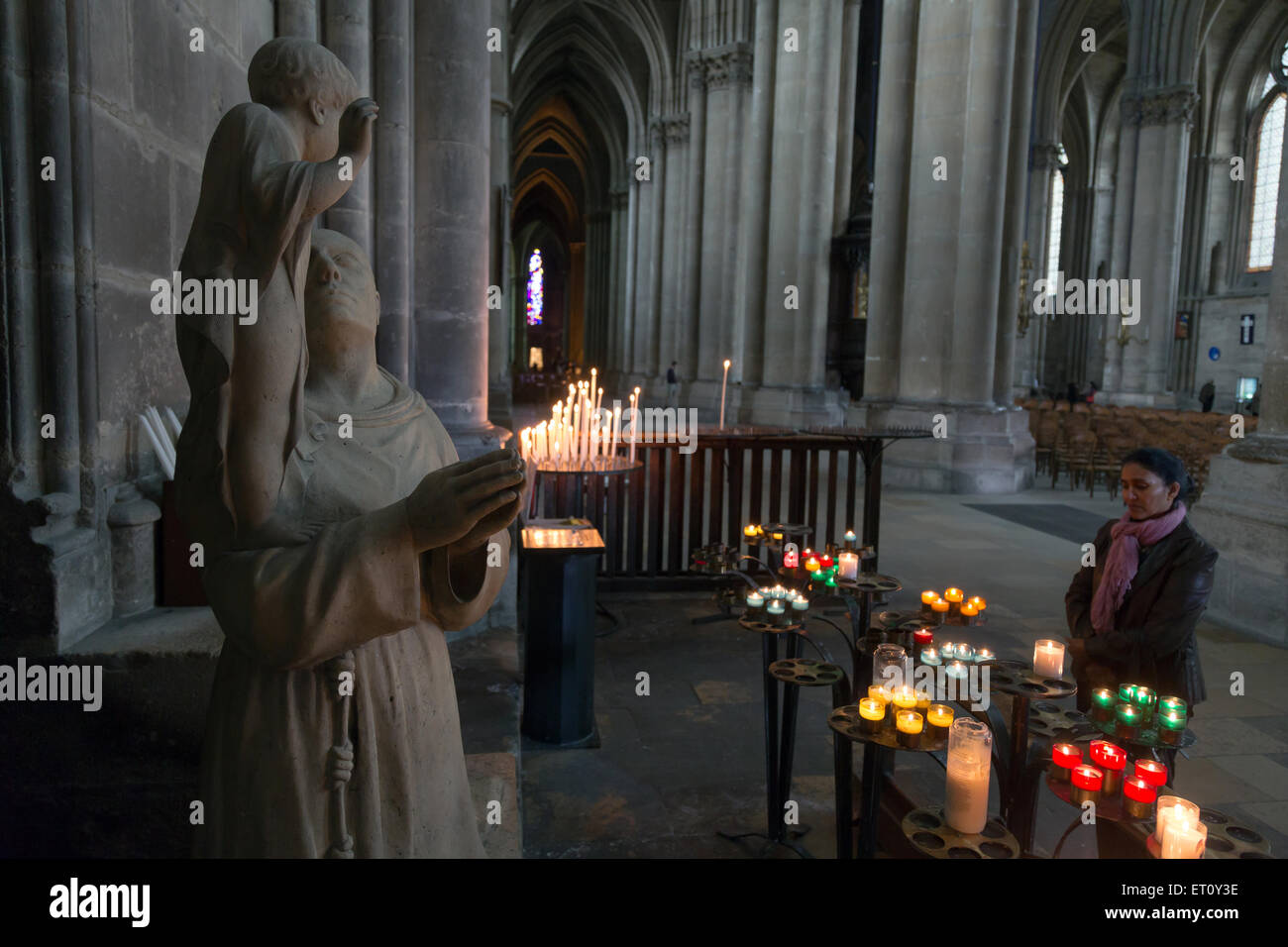 Reims, Frankreich, Kerzen vor einer Skulptur eines Heiligen in der Kathedrale Notre-Dame Stockfoto